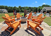 Thumbnail 7 of 37 - A fire pit surrounded by chairs in the middle of a stone circle.