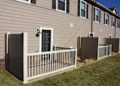 Thumbnail 27 of 37 - A house with a white fence and a brown siding.