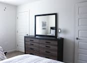Thumbnail 36 of 37 - A bedroom with a bed, dresser, and mirror.