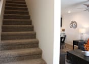 Thumbnail 33 of 37 - A staircase with a carpeted runner and a fan in the room.