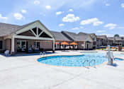 Thumbnail 2 of 37 - A pool area with a building in the background.