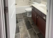 Thumbnail 78 of 78 - A bathroom with a toilet, sink, and mirror.