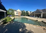 Thumbnail 20 of 78 - A pool surrounded by a stone wall and chairs.