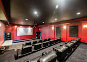Thumbnail 76 of 78 - A movie theater with red walls and black seats.