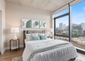 Thumbnail 2 of 35 - a bedroom with a large bed and a large window with a city view