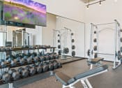 Thumbnail 17 of 35 - a view of the fitness center with cardio equipment and a large screen tv