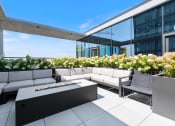 Thumbnail 24 of 35 - a terrace with couches and a firepit on the top of a building