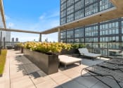 Thumbnail 22 of 35 - a roof top terrace with lounge chairs and a view of the chicago skyline
