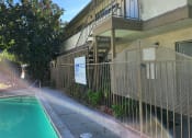 Thumbnail 3 of 8 - an apartment building with a swimming pool and a fence