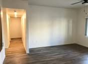 Thumbnail 13 of 29 - an empty living room with a wood floor and a ceiling fan
