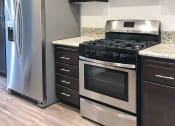 Thumbnail 7 of 29 - a kitchen with stainless steel appliances and wooden cabinets
