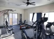Thumbnail 28 of 29 - a home gym with exercise equipment and a ceiling fan