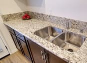 Thumbnail 10 of 29 - a kitchen with a stainless steel sink and granite counter top