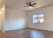 Thumbnail 15 of 29 - an empty living room with a ceiling fan and a window