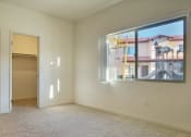 Thumbnail 16 of 29 - an empty living room with a window and a door to a bathroom