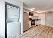 Thumbnail 5 of 5 - A white fridge and oven in a kitchen with wooden flooring.