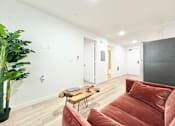 Thumbnail 10 of 19 - A living room with a red couch and a wooden coffee table.