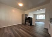 Thumbnail 4 of 6 - A room with a wood floor and a wall-mounted TV.