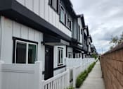 Thumbnail 9 of 14 - A row of white houses with black trim.