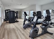 Thumbnail 8 of 14 - A spacious gym with a variety of cardio equipment.