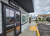 Thumbnail 13 of 14 - The image shows the front of a leasing office with a sign above the door.