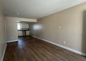 Thumbnail 1 of 13 - A room with wooden flooring and a window.