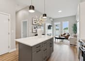 Thumbnail 8 of 21 - A modern kitchen with a white island and wooden floors.