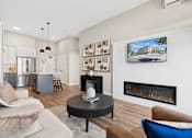 Thumbnail 14 of 21 - A living room with a fireplace and a television on the wall.
