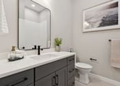 Thumbnail 3 of 21 - A bathroom with a white sink and a white toilet.