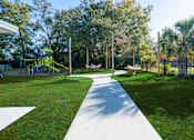 Thumbnail 60 of 61 - A playground with a yellow slide and a white pathway. at Red Bay Apartment Complex, Jacksonville, FL, 32211