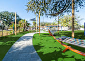 Thumbnail 31 of 61 - A park with a hammock between two trees. at Red Bay Apartment Complex, Jacksonville, FL, 32211