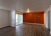 Thumbnail 54 of 61 - an empty living room with a red accent wall at Red Bay Apartment Complex, Jacksonville