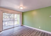Thumbnail 38 of 61 - a living room with green walls and a sliding glass door to a balcony at Red Bay Apartment Complex, Jacksonville, FL, 32211
