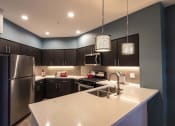 Thumbnail 16 of 28 - a kitchen with a large island and stainless steel appliances
