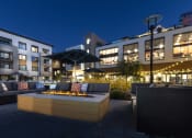 Thumbnail 3 of 28 - a patio with a fire pit and seating in front of a building