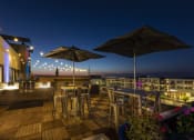 Thumbnail 2 of 28 - a rooftop bar with tables and chairs and umbrellas