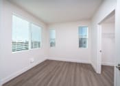 Thumbnail 3 of 12 - an empty room with white walls and wood flooring and windows