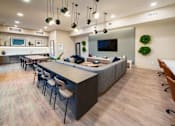 Thumbnail 9 of 12 - a communal area with a long table and chairs and a kitchen with a television