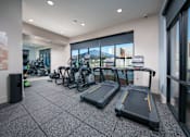 Thumbnail 7 of 12 - a gym with cardio machines and bikes in the lobby of a building
