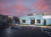 Thumbnail 1 of 12 - the exterior of a building with a parking lot