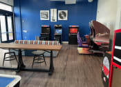 Thumbnail 25 of 28 - a recreation room with a table and arcade games