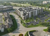Thumbnail 2 of 4 - A large building with a parking lot in front of it.