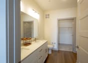 Thumbnail 24 of 26 - A bathroom with a toilet, sink, and mirror.