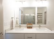 Thumbnail 32 of 34 - A bathroom with two sinks and a large mirror.