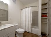 Thumbnail 23 of 26 - A white bathroom with a toilet, sink, and shower.