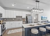 Thumbnail 1 of 29 - Modern kitchen with white cabinetry and island seating at Viridian Apartments, Bowling Green, KY