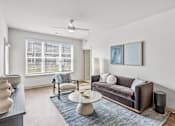 Thumbnail 3 of 29 - Modern living room with brown sofa and blue accents at Viridian Apartments, Bowling Green, Kentucky