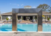 Thumbnail 23 of 27 - a swimming pool with a building in the background at Arlington Farms, Greenwood, Indiana