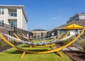 Thumbnail 24 of 27 - a group of hammocks in the backyard of an apartment building at Arlington Farms, Greenwood, IN, 46143