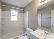 Thumbnail 6 of 30 - a bathroom with a white toilet next to a white sink and tub